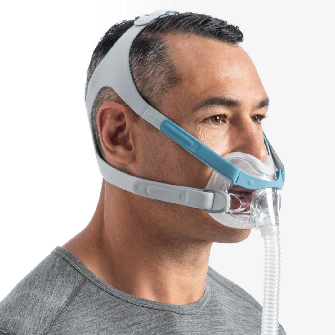 Person wearing Fisher & Paykel Evora Full Face CPAP Mask FitPack with under-the-nose cushion and breathable headgear connected to CPAP tubing for sleep apnea therapy